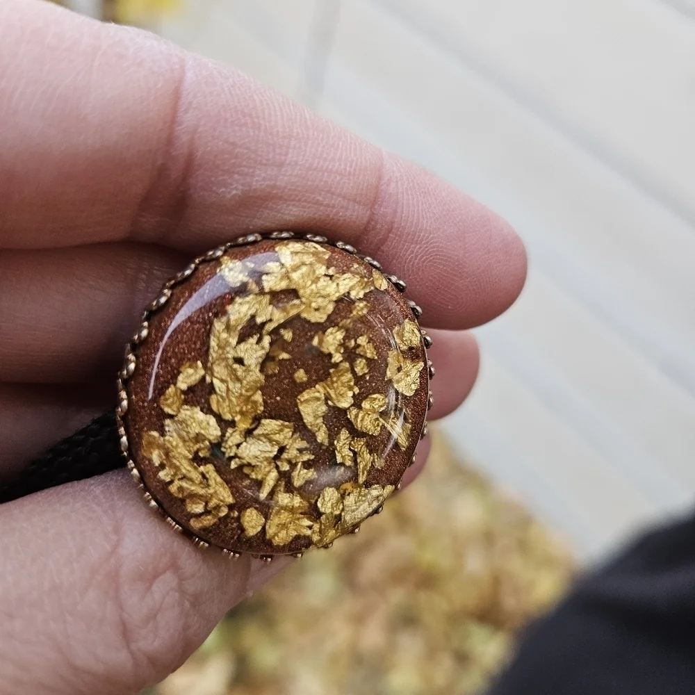 gold leaf and goldstone bolo tie on brown cord